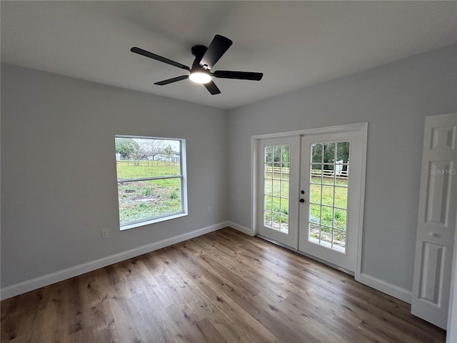 spare room featuring wood finished floors, a healthy amount of sunlight, and french doors