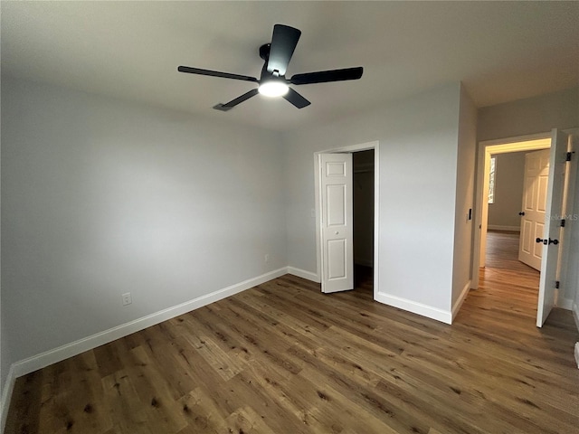 unfurnished bedroom featuring ceiling fan, baseboards, and wood finished floors
