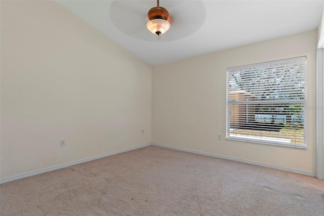 empty room with light carpet, a ceiling fan, and baseboards