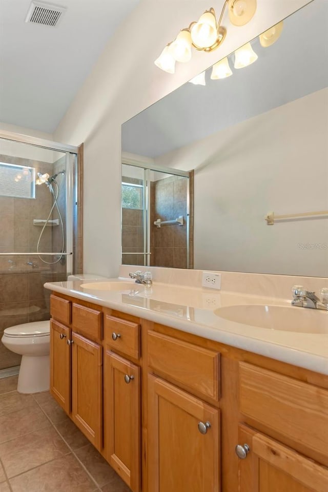 full bath featuring double vanity, a stall shower, visible vents, tile patterned floors, and a sink