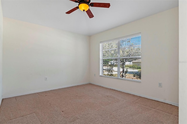 carpeted empty room featuring ceiling fan and baseboards