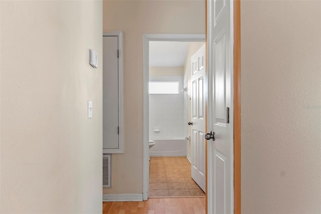 hall featuring light tile patterned floors and visible vents