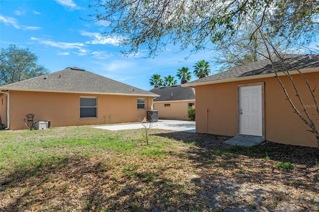 back of house with a patio, central AC unit, a lawn, and stucco siding