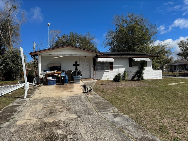 ranch-style home with concrete driveway, a front lawn, and brick siding