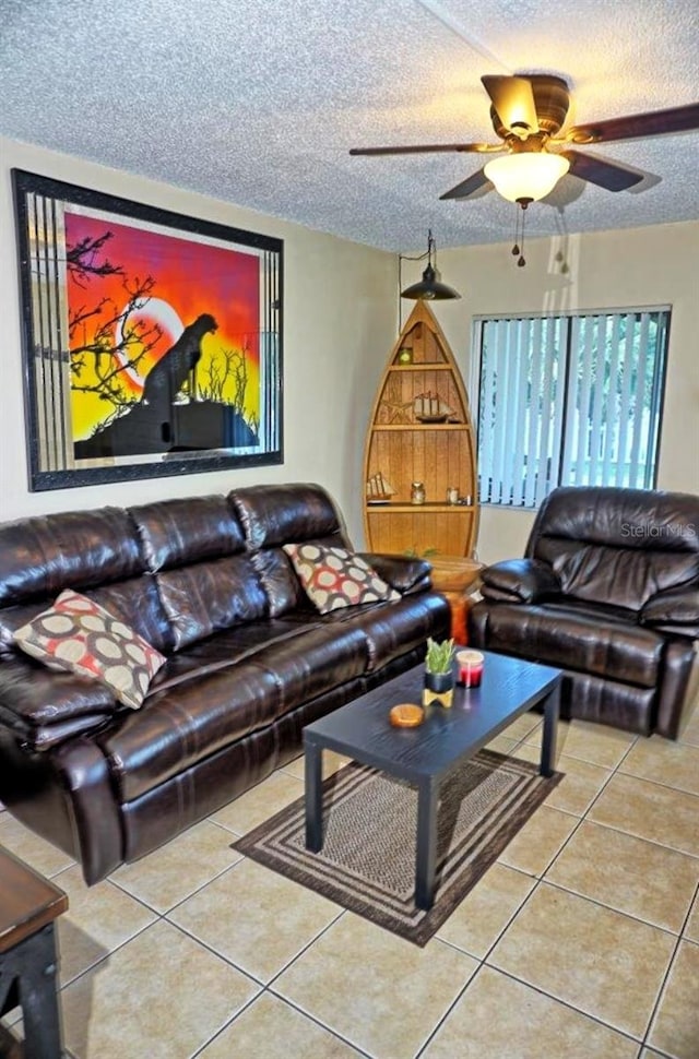 tiled living area featuring ceiling fan and a textured ceiling