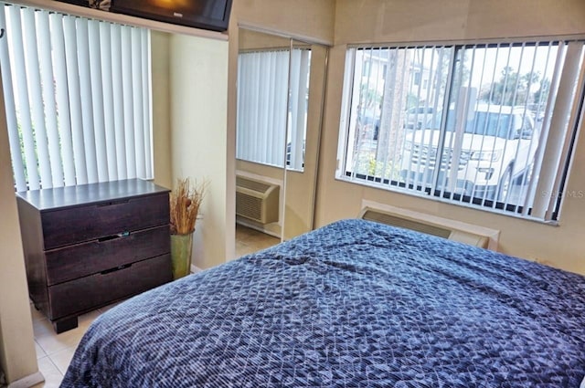 bedroom featuring a wall unit AC and light tile patterned floors