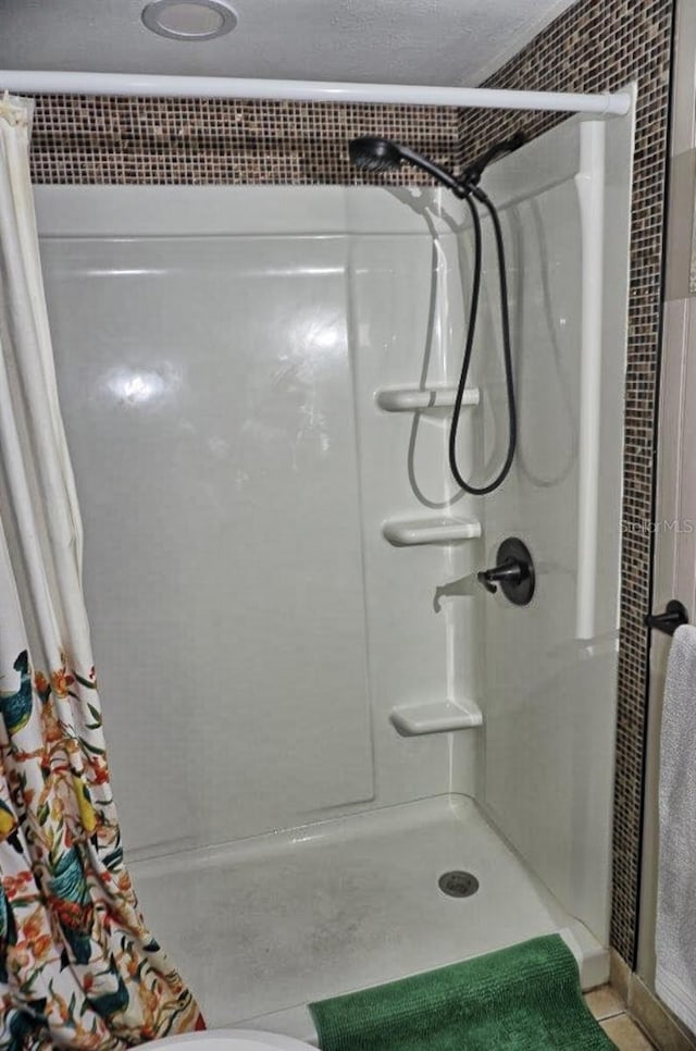 full bathroom with a stall shower and tile patterned flooring