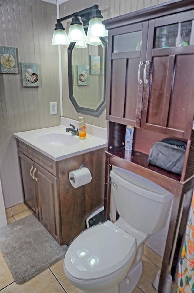 bathroom with toilet, vanity, and tile patterned floors