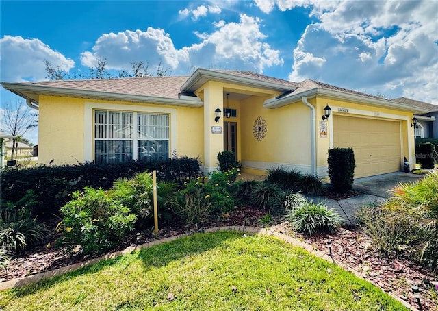 view of front facade with a garage, driveway, and stucco siding