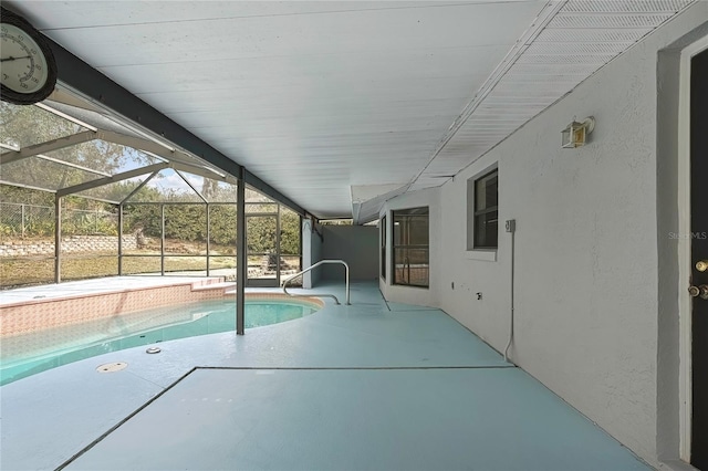 outdoor pool featuring glass enclosure and a patio area