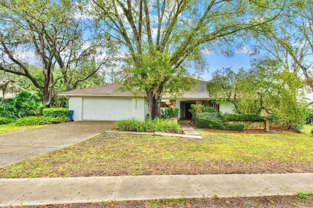 view of front of property featuring a garage, driveway, a front yard, and stucco siding