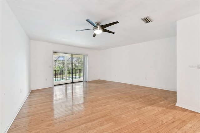 empty room with light wood-style floors, ceiling fan, and visible vents