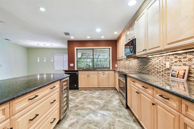 kitchen with dark stone counters, a sink, black appliances, and light brown cabinetry