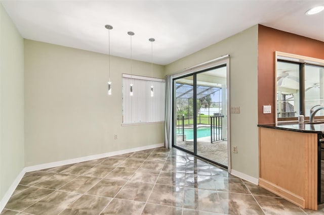 entryway featuring tile patterned floors, a sink, a sunroom, and baseboards