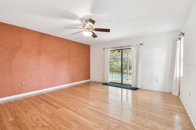 unfurnished room with light wood finished floors, baseboards, and a ceiling fan