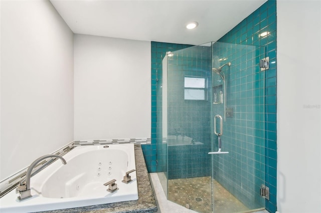 bathroom with a jetted tub and a shower stall