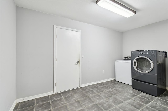 washroom with laundry area, washer and clothes dryer, and baseboards