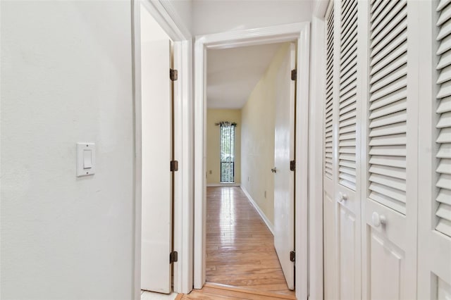 hall featuring light wood finished floors and baseboards