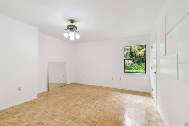 unfurnished room with a ceiling fan and baseboards