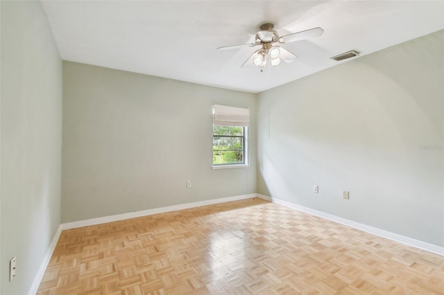 unfurnished room featuring a ceiling fan, visible vents, and baseboards