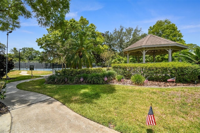 surrounding community with fence, a lawn, and a gazebo