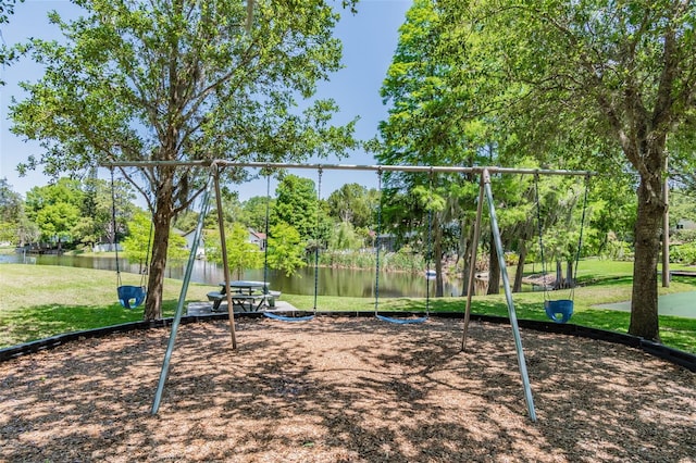 view of play area featuring a lawn and a water view