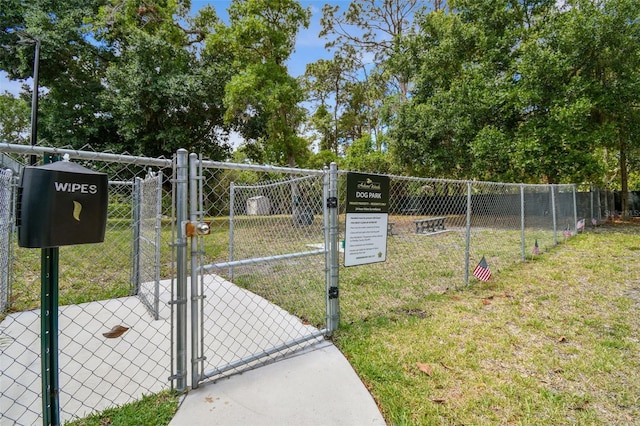 exterior space featuring a gate, fence, and a lawn