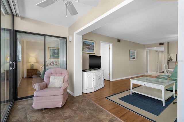 living area featuring ceiling fan, baseboards, visible vents, and dark wood finished floors