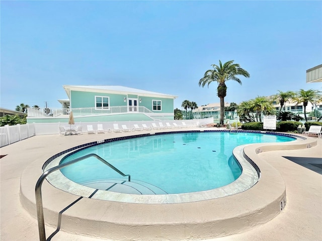 community pool featuring a patio and fence