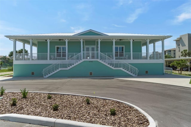 view of front of house featuring covered porch, stairs, and metal roof