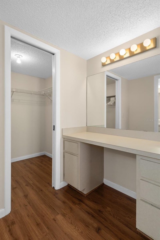 bathroom featuring vanity, a textured ceiling, baseboards, and wood finished floors