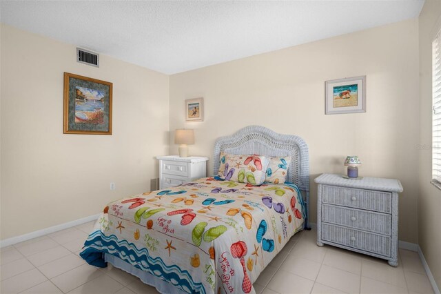 bedroom with light tile patterned floors, visible vents, and baseboards