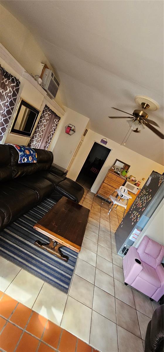 living area featuring a ceiling fan and tile patterned floors