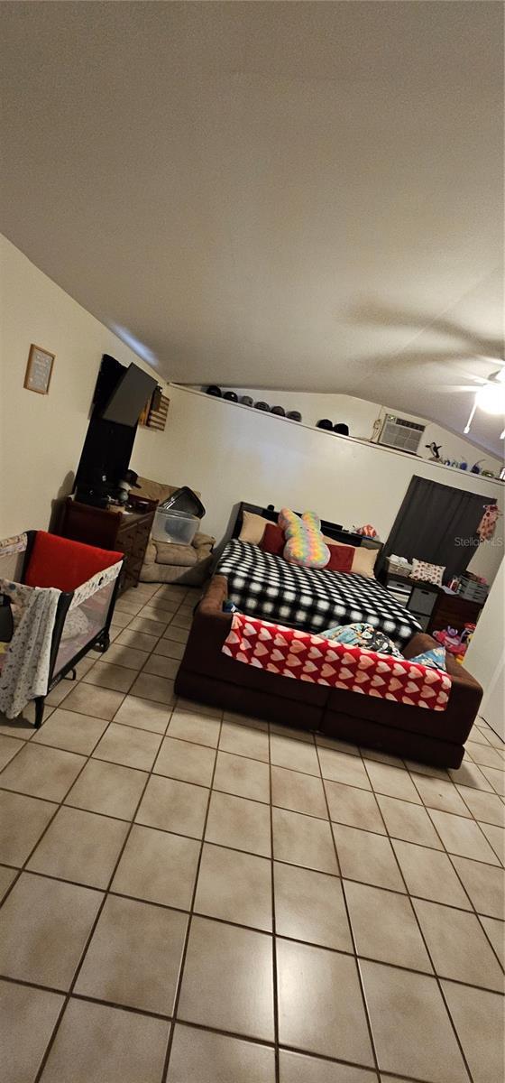 living room featuring lofted ceiling and light tile patterned floors