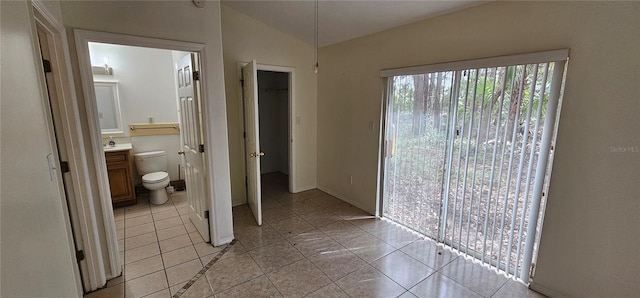 interior space featuring vaulted ceiling and light tile patterned flooring