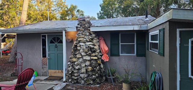 entrance to property featuring metal roof and stucco siding