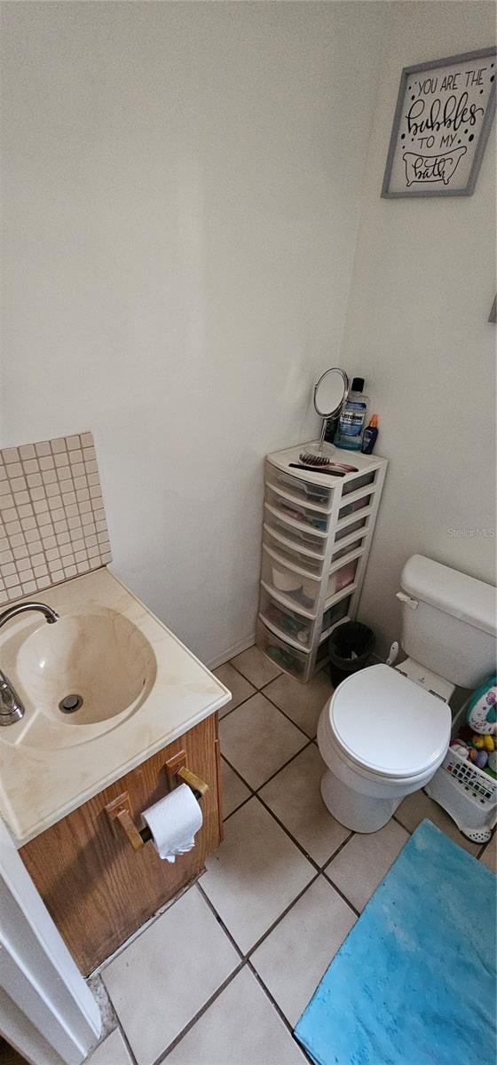 bathroom featuring toilet, tile patterned flooring, and vanity