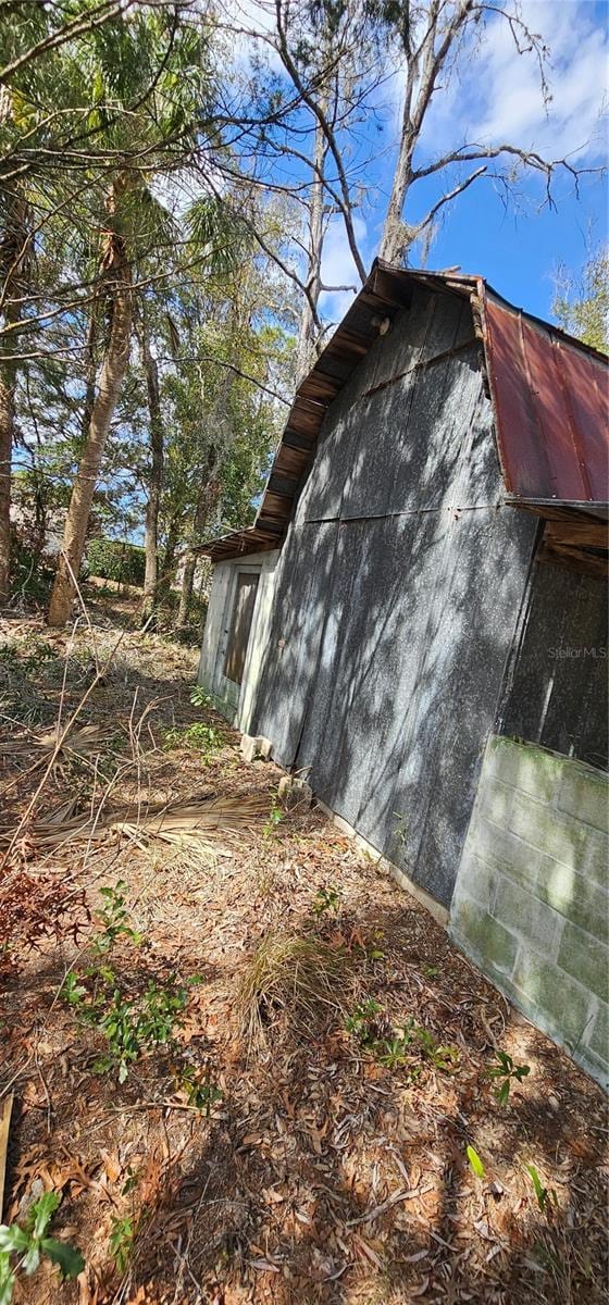 view of home's exterior with an outbuilding and a gambrel roof