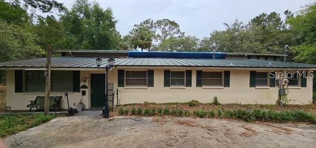 17932 Wendy Sue Ave, Hudson, FL 34667 - view of front of home with a standing seam roof, stucco siding, and a metal roof