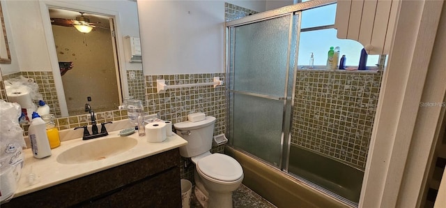 17932 Wendy Sue Ave, Hudson, FL 34667 - full bath with tile walls, vanity, combined bath / shower with glass door, wainscoting, and a ceiling fan