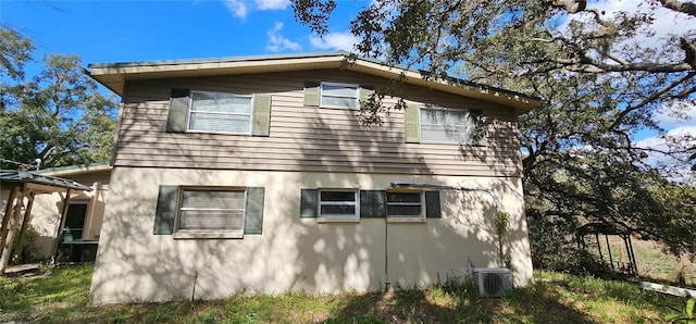 17932 Wendy Sue Ave, Hudson, FL 34667 - view of side of property with a cooling unit and stucco siding