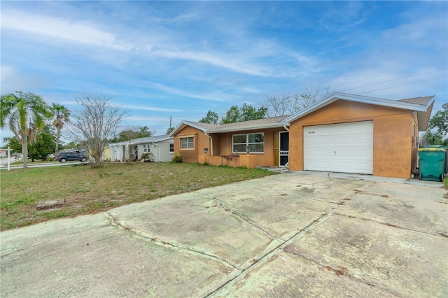 single story home featuring a garage, driveway, a front yard, and stucco siding