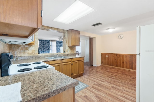 kitchen with range with electric cooktop, a sink, light wood-style floors, light countertops, and freestanding refrigerator