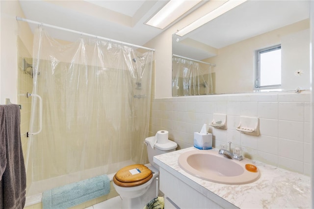 full bathroom with a stall shower, tile walls, vanity, and toilet