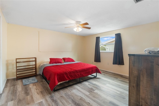 bedroom with ceiling fan, baseboards, and wood finished floors