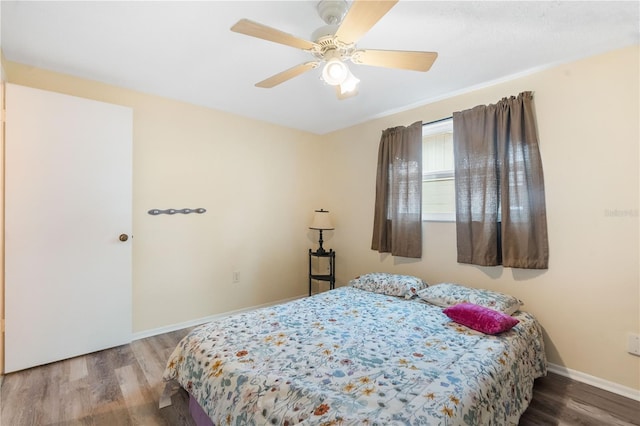 bedroom with ceiling fan, baseboards, and wood finished floors