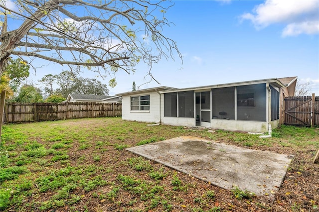 rear view of house with a patio, a lawn, a fenced backyard, and a sunroom