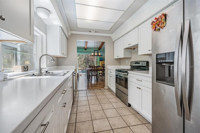 kitchen with light countertops, appliances with stainless steel finishes, a sink, and white cabinets