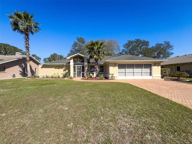 view of front facade featuring an attached garage, stucco siding, decorative driveway, and a front yard