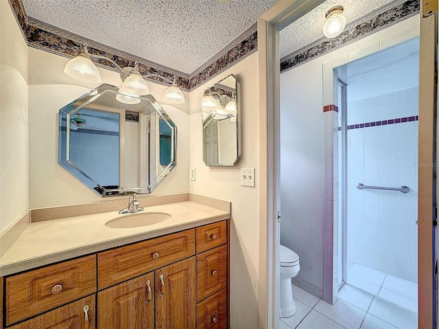 full bath with toilet, tile patterned flooring, a tile shower, a textured ceiling, and vanity